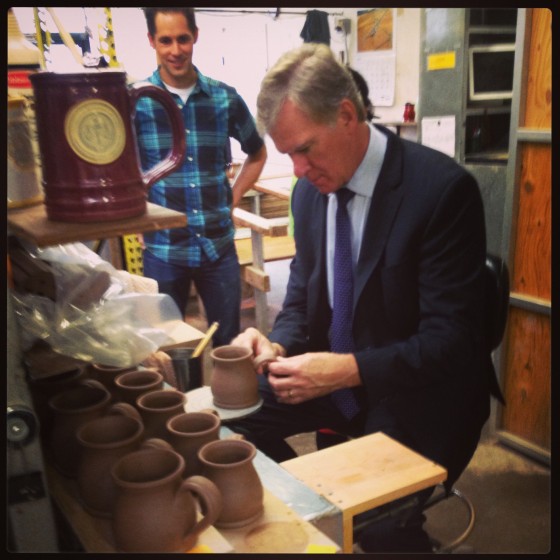 Mayor Chris Coleman putting handles on mugs 