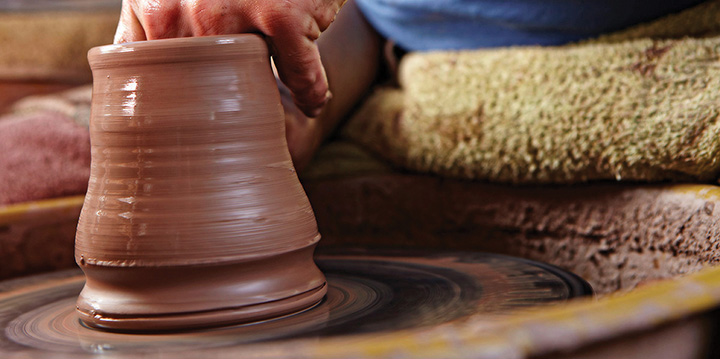 Mugs being pulled on the potter's wheel 